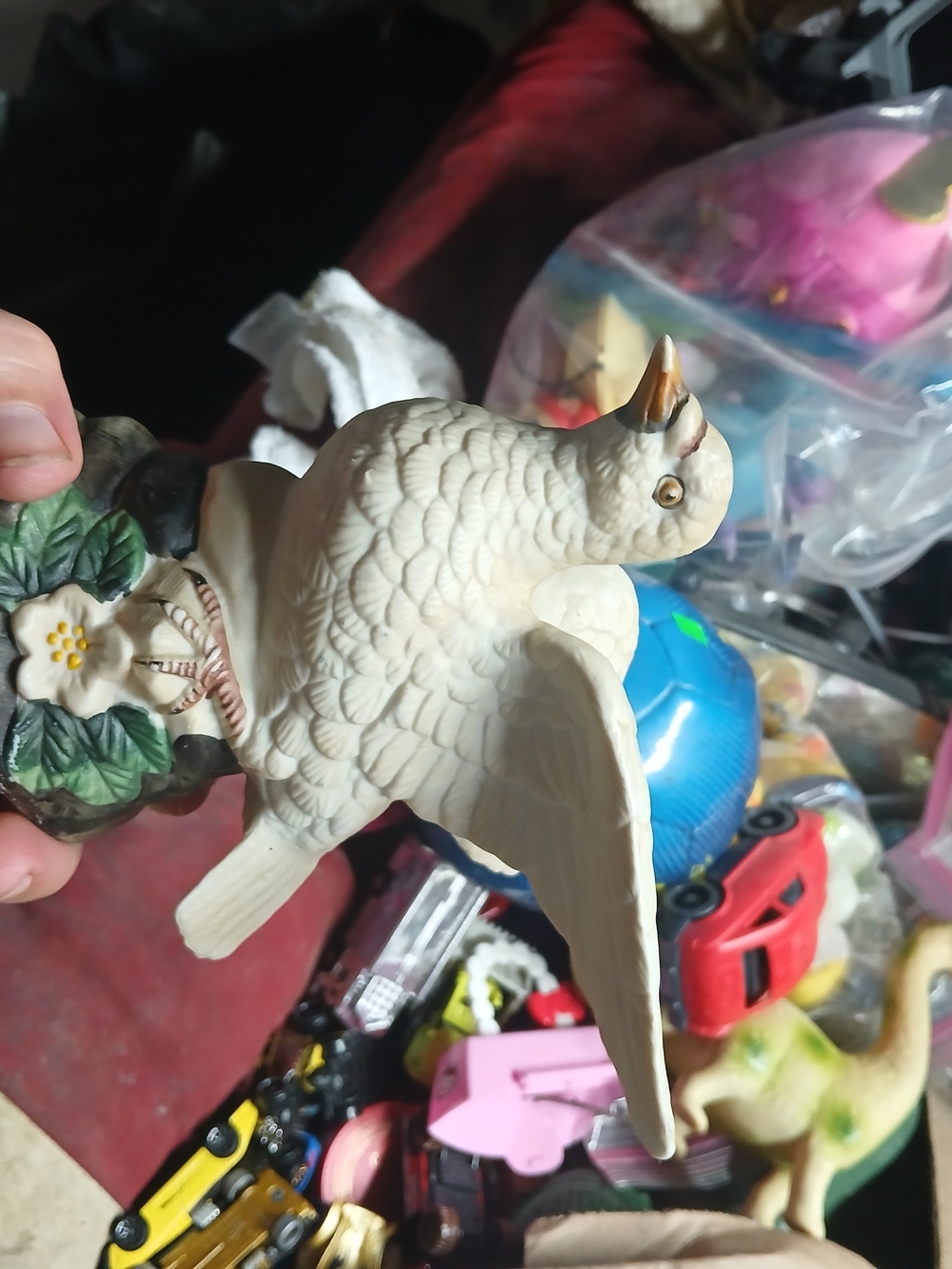 show a vintage bisque or fine porcelain white dove figurine perched on a rocky b